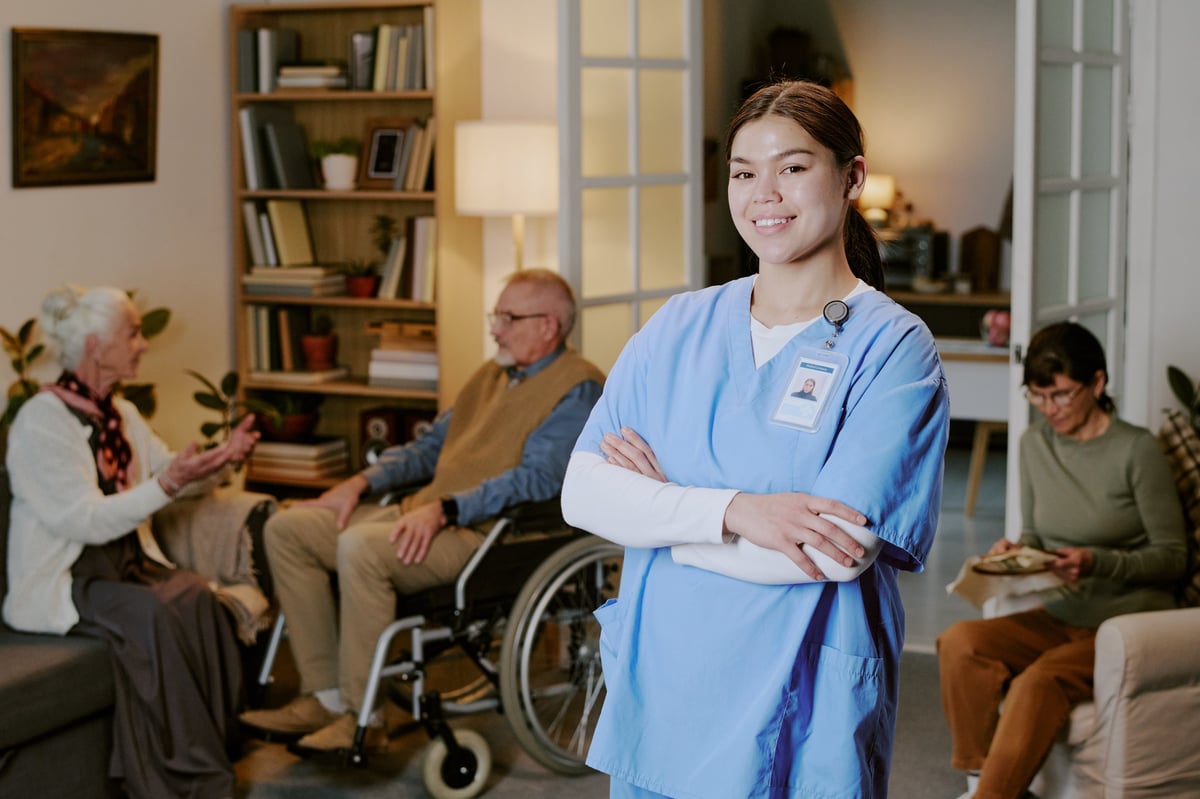 Smiling nurse with seniors in warm care facility setting