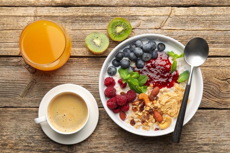 Healthy breakfast with oatmeal, berries, coffee and orange juice on table